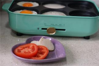 然后将鱼饼及番茄切片，再入另外二个模里煎烙。