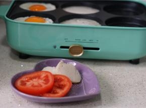 然后将鱼饼及番茄切片，再入另外二个模里煎烙。