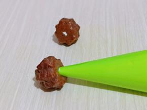 这时泡芙也凉了，用筷子捅个小洞洞，再将裱花嘴插入洞洞里，挤入奶油即可。