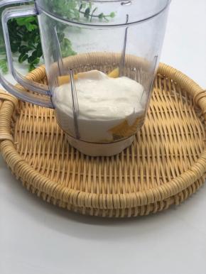 搅拌机里加入芒果粒和一整盒酸奶。