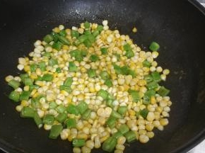 锅里热油，倒入四季豆、玉米粒翻炒