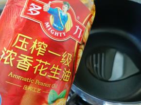 另起一个不粘锅，倒入多力浓香花生油。