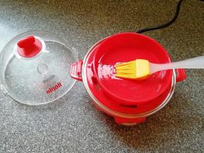 放上蛋托盘，将煎蛋盘放在蛋托盘上面，刷上一层食用油。