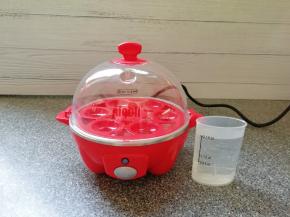 准备好煮蛋器，用量杯取最高水位的水加入到蒸盘里面。