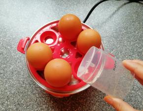 用量杯下面的钢针将鸡蛋大头一端戳一个小洞(避免煮的过程中鸡蛋破裂)，将鸡蛋放在蛋托盘上面。