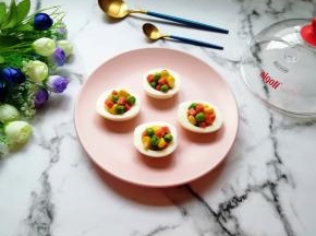 将炒好的豌豆、玉米粒和火腿肠盛入蛋白里面。