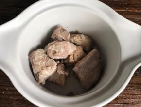 把焯水后的排骨放入蒸碗中，加入料酒