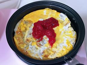 袋蛋液凝固后，再把手抓饼翻面，涂上自制草莓酱。