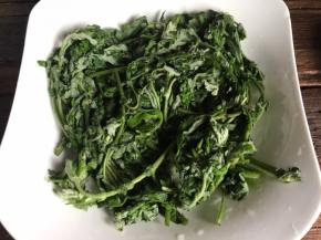 艾叶摘洗干净，沥水后，用一半铺满盘底