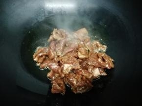 锅里加入适量的油，烧到七成热时，把腌好的牛肉放入锅中，快速翻炒到牛肉熟