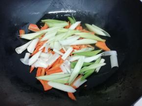 放入青蒜和葱，翻炒片刻