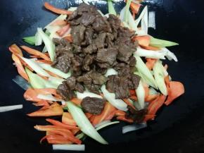 再把炒好的牛肉放入锅中，翻炒几下，然后加入鸡精即可关火出火出国