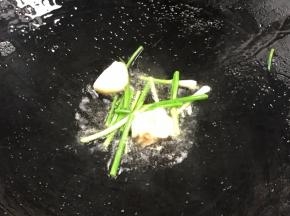 热锅烧热猪油，爆香蒜瓣和葱段