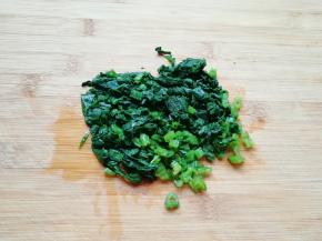 焯过水的菠菜捞出晾凉，攥去多余的水分切碎。