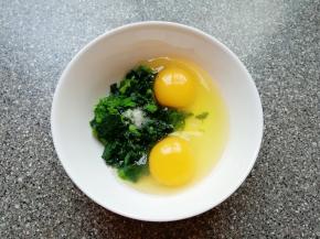 将切碎的菠菜放入碗中，打入两个鸡蛋，放一点盐。