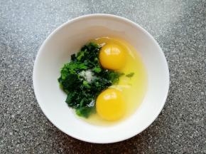 将切碎的菠菜放入碗中，打入两个鸡蛋，放一点盐。