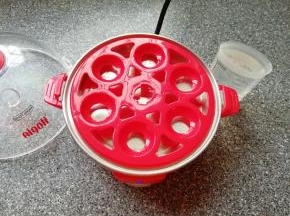 准备好煮蛋器，放上蛋托盘，用量杯取最高水位的水加入到蒸盘里面。
