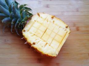 先来处理菠萝，将菠萝从叶子下面的三分之一处切开，少的一半去皮只取菠萝果肉，带叶子的一半用水果刀划十字，用勺子挖出菠萝果肉。