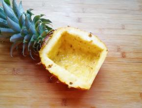 挖完果肉的菠萝就变成了一个菠萝碗，在菠萝碗里面放一点点盐，倒入纯净水，浸泡5分钟左右倒掉淡盐水，用厨房用纸吸一吸菠萝碗里多余的水分。