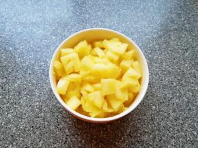 取一个大一点容器，放一点点盐加入纯净水，将菠萝果肉在淡盐水里面泡5分钟左右取出，一半的菠萝果肉切成小块炒饭用，另一半可以直接吃了。