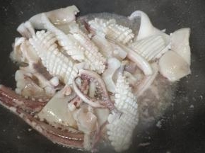 锅里继续倒入鲜鱿鱼炒至断生盛出备用