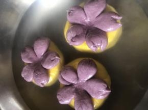 水烧至微开，放贝果进去每面煮30~60秒 轻轻翻动 避免破坏造型 
用漏勺捞起 摆在烤盘上
花心的部分 可以用刮刀把再怼一下，撒少量黑芝麻做花心装饰