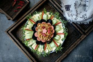 把调料倒在盘中间即可，刻一个火腿肠花做装饰