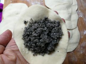 取一小块幹成中间厚，边缘薄的皮，放入黑芝麻馅