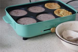 在多用锅的六孔模里刷上少许许一点油，然后将红豆面糊盛在里面。