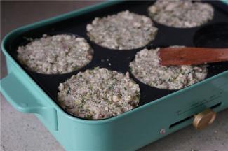 多用锅里刷上一层薄油，将拌好的食材盛压至六孔模里面。