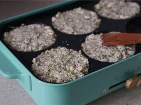 多用锅里刷上一层薄油，将拌好的食材盛压至六孔模里面。