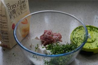 将豆腐，糕点用小麦粉，肉末，葱末拌在一起，加入细盐及玉米油还有胡椒粉拌至上劲入味。