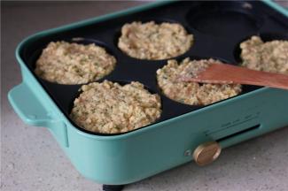 将拌好的食材码放在六孔模里面。