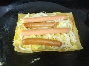 把加热好的香肠放上（放二条最好，太多会难卷，我这个太多了）