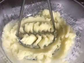 取出蒸好的土豆，倒入大点的容器中，压成泥状