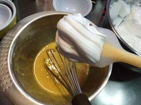 取出准备好的蛋黄糊，加入一半蛋白霜，2点钟方向进，8点钟的方向出，把蛋白带进去，搅拌的过程中一定不要抬高把空气但进去哦。