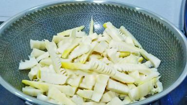 油热倒入雷笋炒至笋边缘变黄。