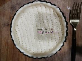 面团发酵完成后，移至面板上排气擀圆，放入6寸披萨盘，用叉子戳出小洞，以免烘烤时鼓起