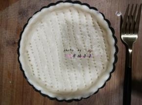 面团发酵完成后，移至面板上排气擀圆，放入6寸披萨盘，用叉子戳出小洞，以免烘烤时鼓起