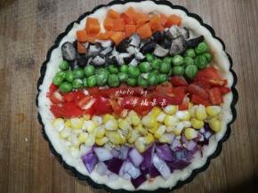 在芝士上面一行行摆上提前备好的各种颜色的蔬菜粒，按照你喜欢的颜色一排排摆好，就成美丽的彩虹形状了，然后在蔬菜层上面撒上一点盐和黑胡椒粉