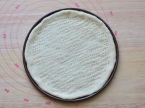 放在披萨盘里面，用叉子在面饼上面扎一些小孔，防止烤的时候鼓起来