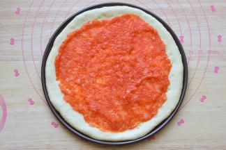 做好的面饼上面涂抹自制的披萨酱