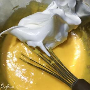 蛋清分2-3次加入细砂糖，（烤箱这时可以开始预热了）打发至湿性发泡状态。取三分之一拌入蛋黄糊中拌匀，。