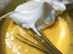 蛋清分2-3次加入细砂糖，（烤箱这时可以开始预热了）打发至湿性发泡状态。取三分之一拌入蛋黄糊中拌匀，。