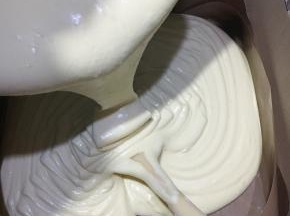 倒入铺好油布的模具中，油布四周铺上硬纸片，有助蛋糕长高不易回落。