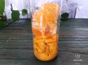将芒果果肉与澳柑果肉一同放进果汁杯中。