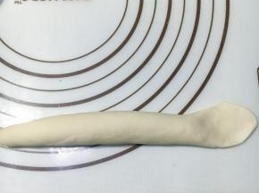 收口朝上，搓成差不多18厘米的长条，一端压扁平。