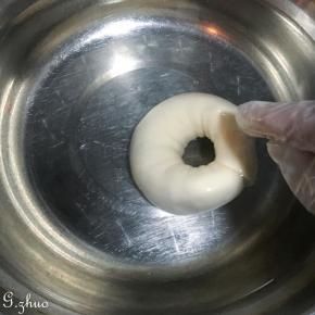 发酵好的贝果可提前放入冰冷冻半小时，另一种方法是用碱水加温水，先放温水再放烘焙碱，是烘焙碱哦，不是家里的食用碱，那口感并不好，操作时请带上一次性手套，双面在碱水中稍微翻滚后沥干水，放入烤盘，