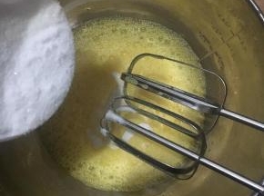 三个全蛋隔热水打至鱼眼泡泡状加入二分之一白砂糖继续打至细泡再加入第二次。