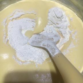 离开热水盆，过筛入蛋糕粉，翻拌均匀。